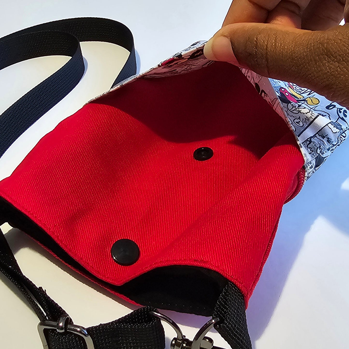 Crossbody phone bag displaying secure popper fastening back compartment