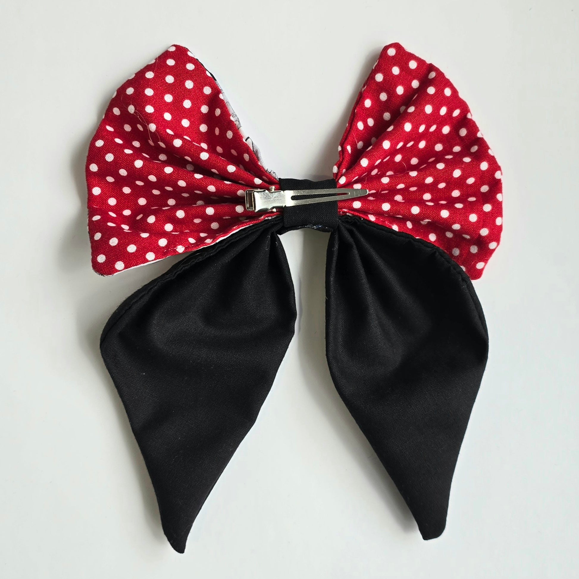 Rear-view of black, red polka dot and character patterned fabric bow