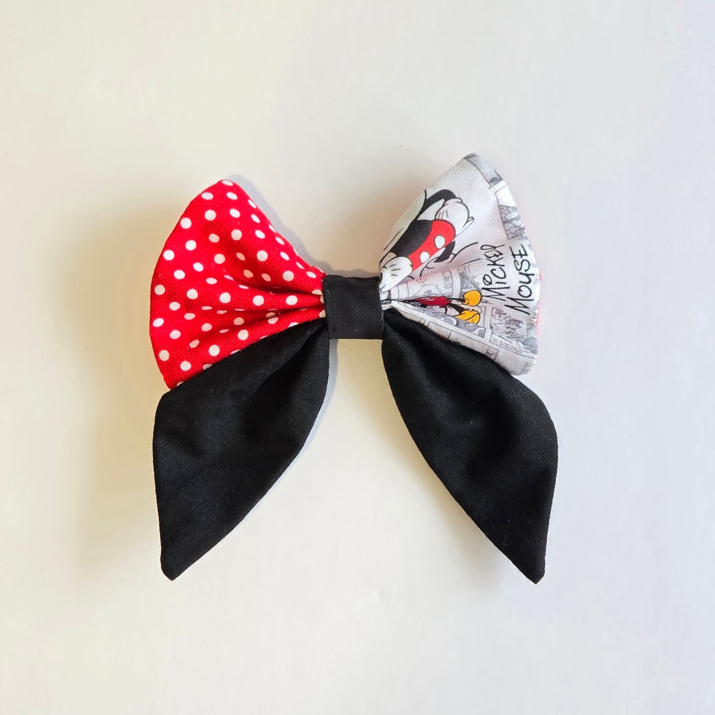 Handmade patchwork hair bow with red polka dot and character-inspired fabric panels