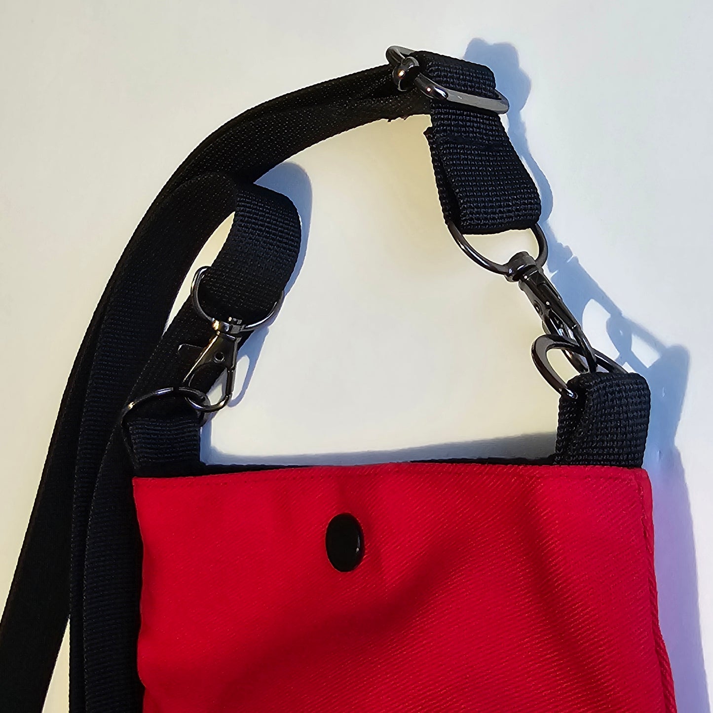 Adjustable black shoulder strap with metal hardware and swivel clips