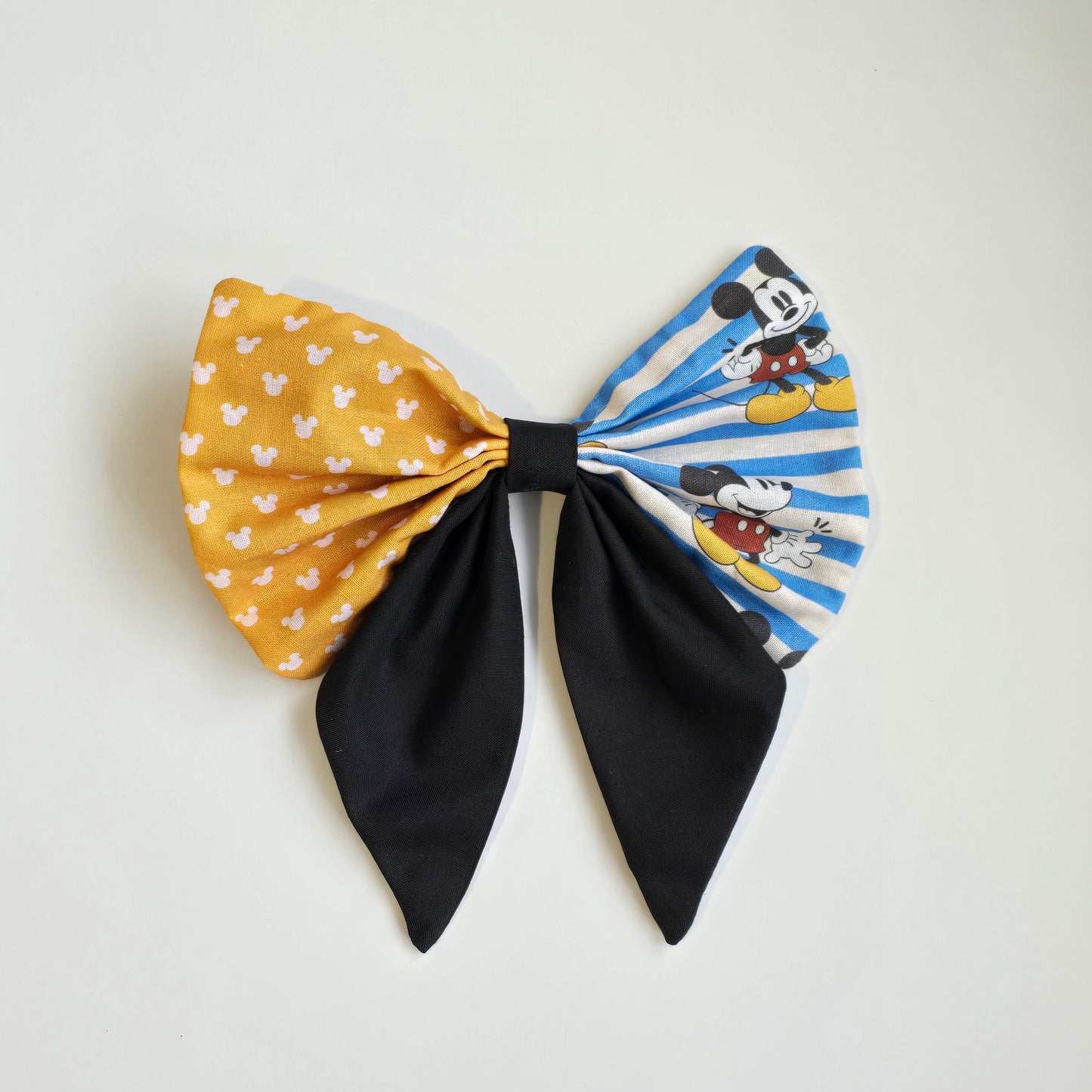 Handmade yellow, blue and black patchwork hair bow with character-inspired fabric panel