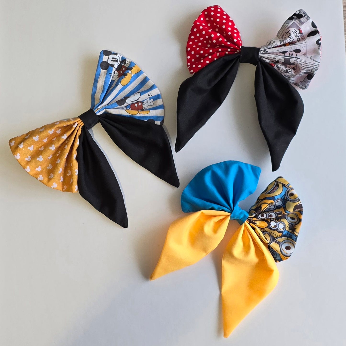 Collection of handmade patchwork hair bows in red, yellow and blue character-inspired fabric designs