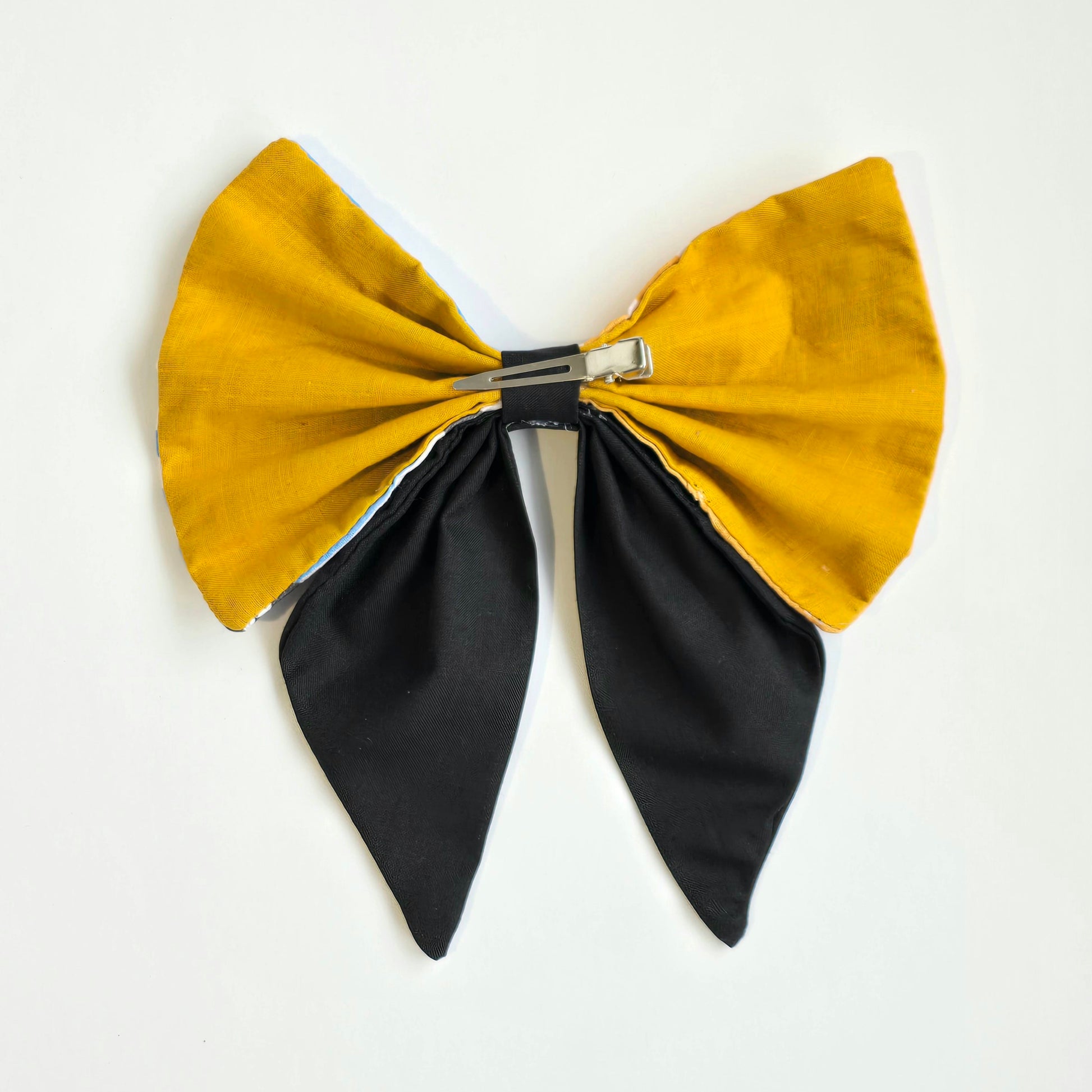 rear-view of yellow, blue and black patchwork hair bow with crocodile clip